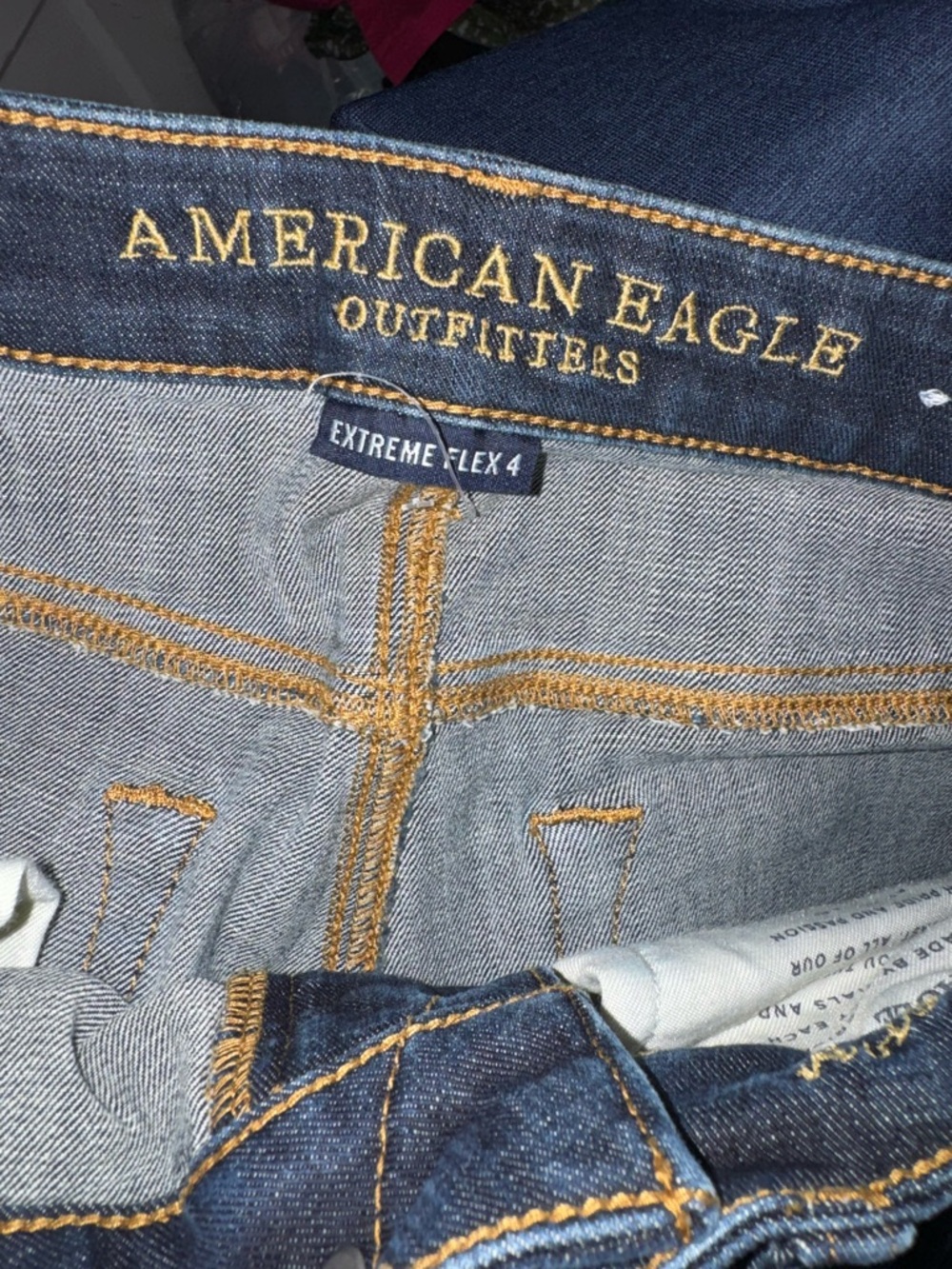 American Eagle Outfitters dark blue denim jeans with gold stitching